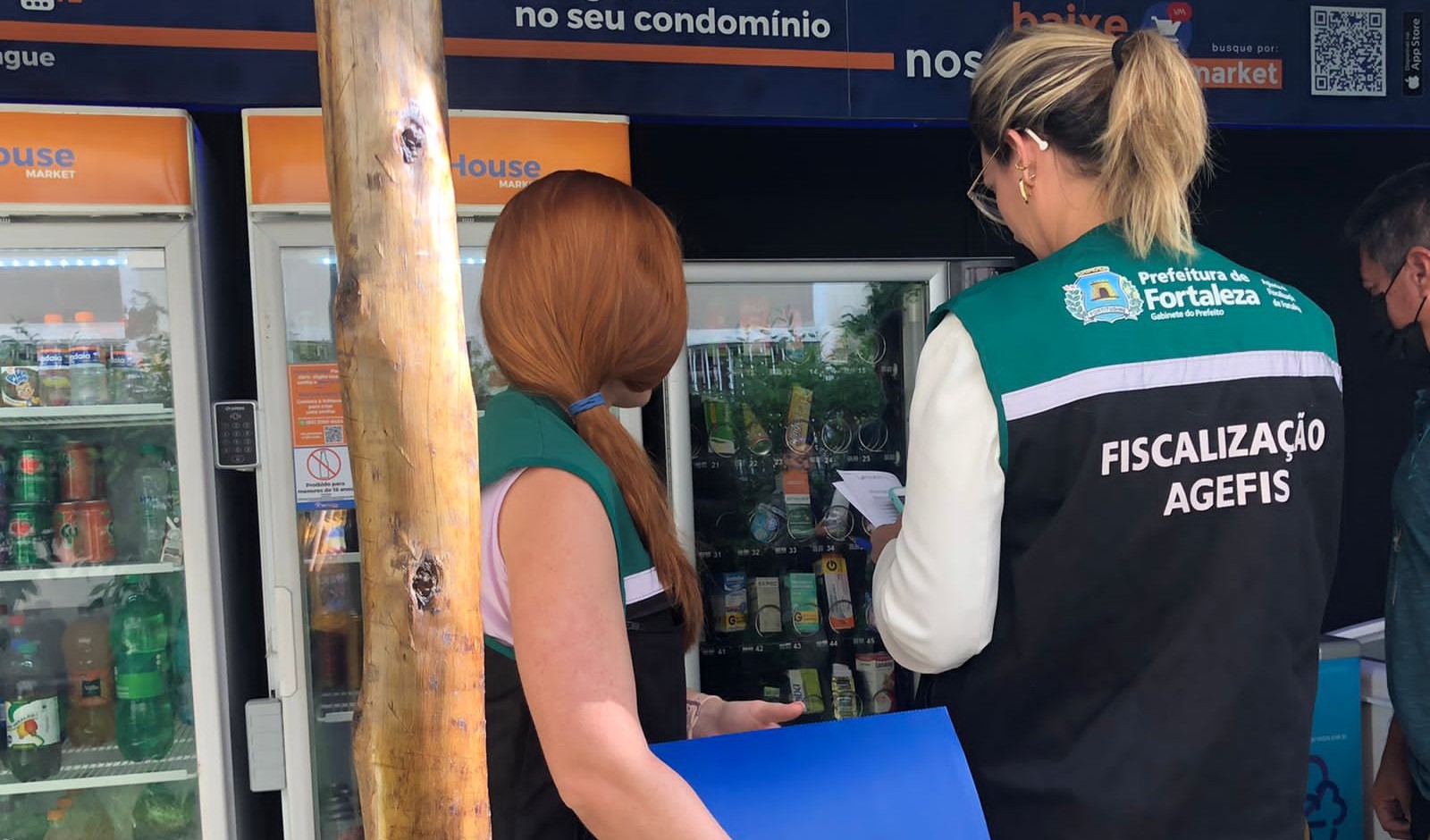 fiscais vistoriam medicamentos denttro de uma geladeira em um condomínio